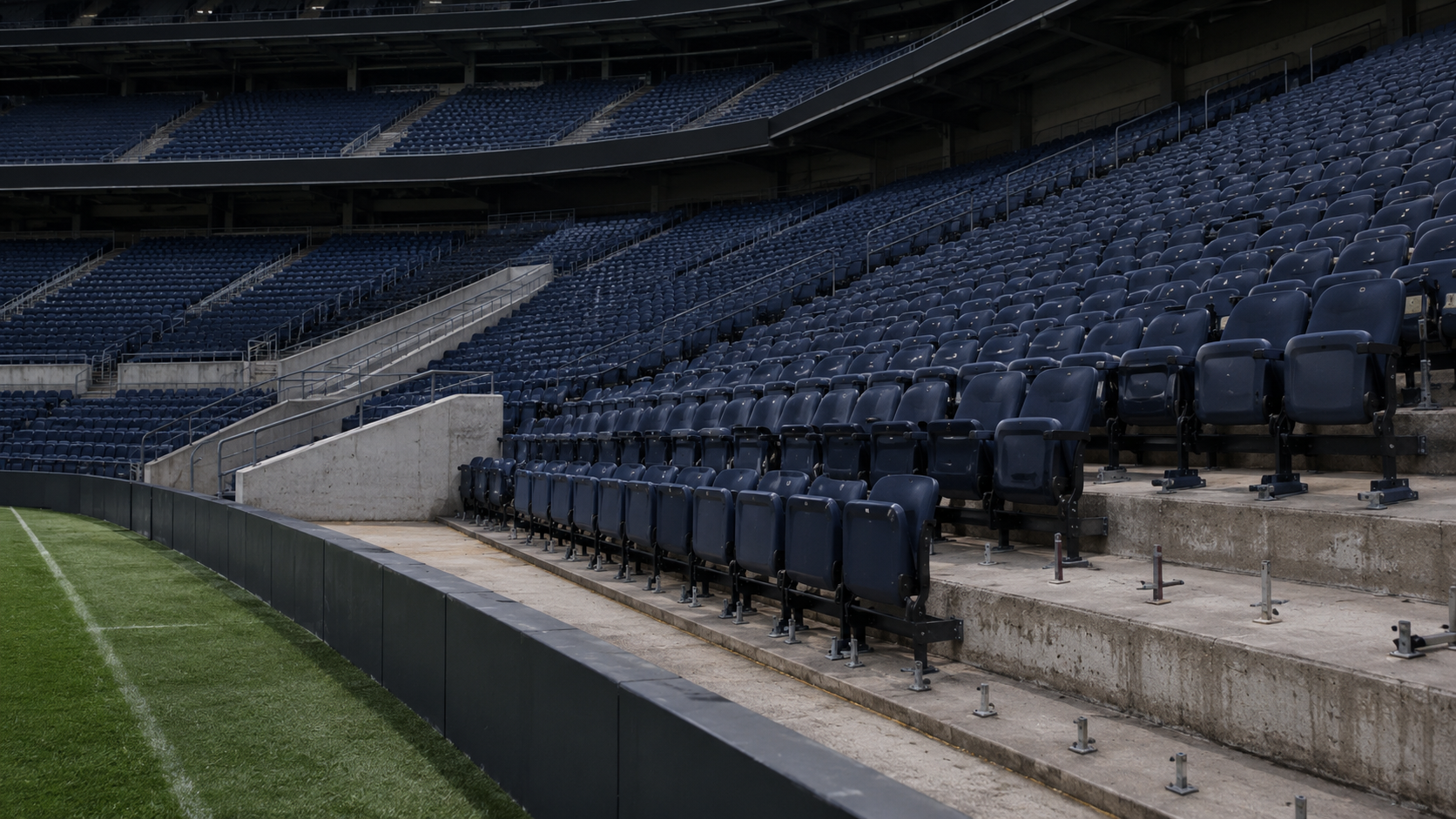 Rangées de sièges vides dans l'angle d'un stade, avec des fixations laissées à nu