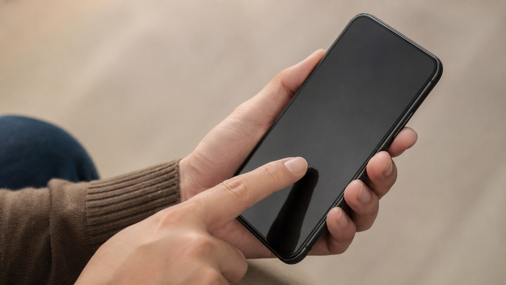 Une main réglant un smartphone générique à l'écran neutre