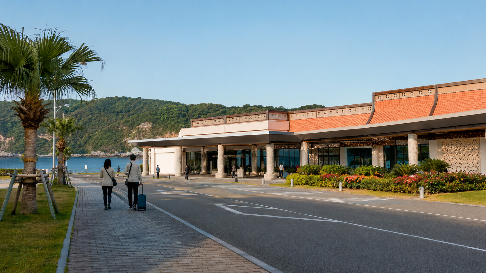 Façade colorée d'un petit aéroport régional japonais entouré de collines vertes