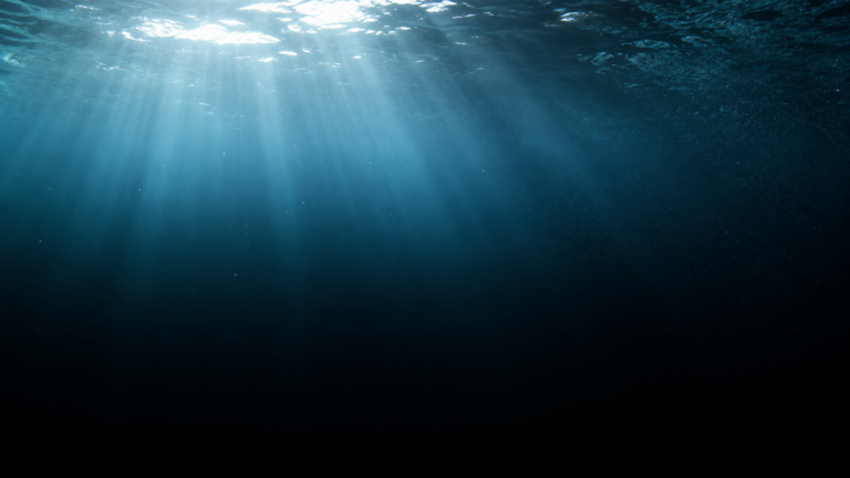 Colonne d'eau douce profonde vue sous la surface, rais de lumière se perdant dans l'obscurité totale