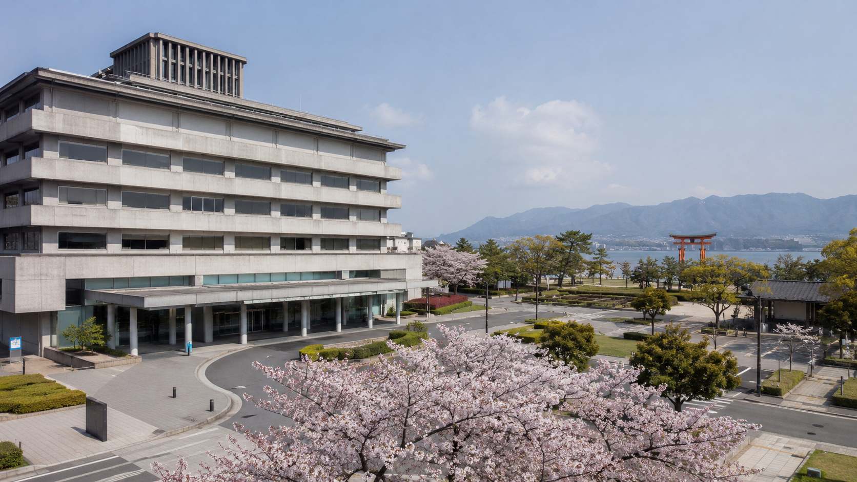 Façade d'une mairie japonaise avec cerisiers et une porte de sanctuaire au loin.