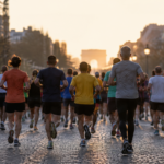Groupe de marathoniens amateurs vus de dos sur une avenue parisienne au petit matin, maillots colorés sans texte lisible