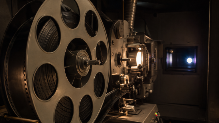 Bobine de pellicule 70 mm posée près d'un projecteur de cinéma dans une cabine de projection