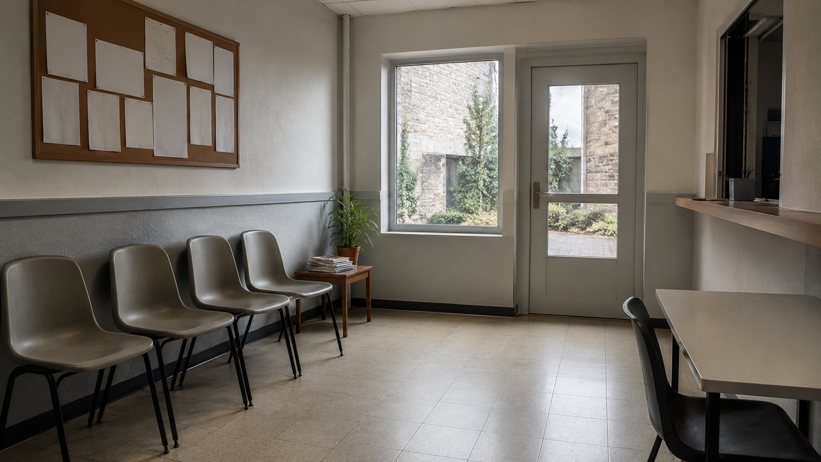 Salle d'attente vide d'un petit bâtiment de service public, rangée de chaises en plastique et panneau d'affichage aux feuilles vierges