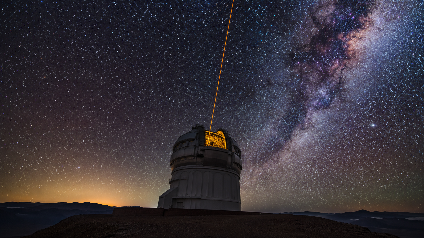 Coupole d'observatoire au sol sous un ciel étoilé, un faisceau laser guide montant vers la Voie lactée