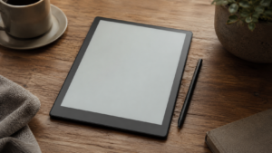 Tablette à encre électronique et son stylet posés sur un bureau en bois, écran vide