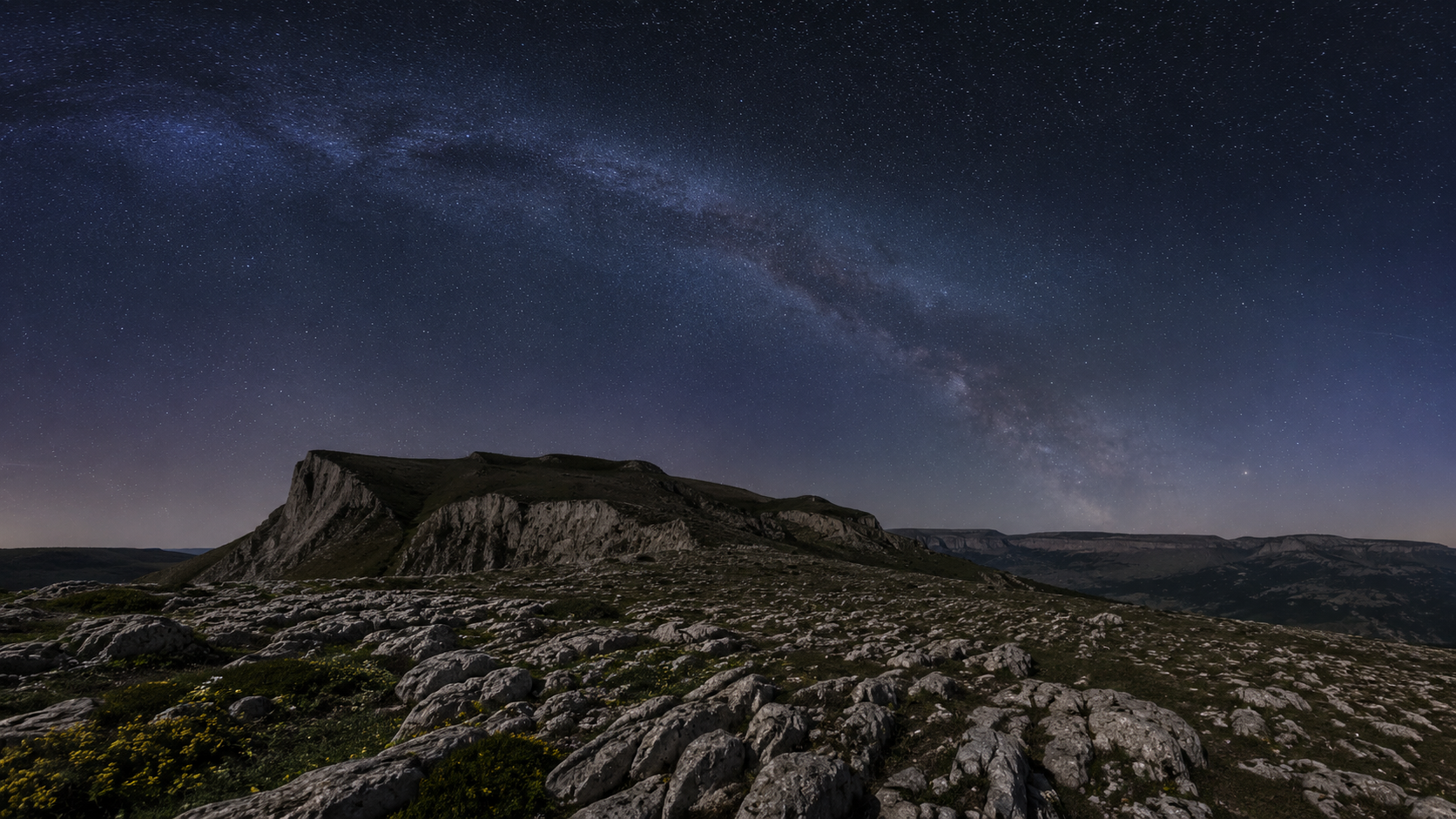 Plateau calcaire de montagne la nuit sous une Voie lactée nettement visible, sans lumière artificielle à l'horizon
