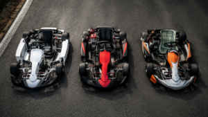 Trois karts miniatures génériques alignés sur une piste grise, vus de dessus, sans pilote.