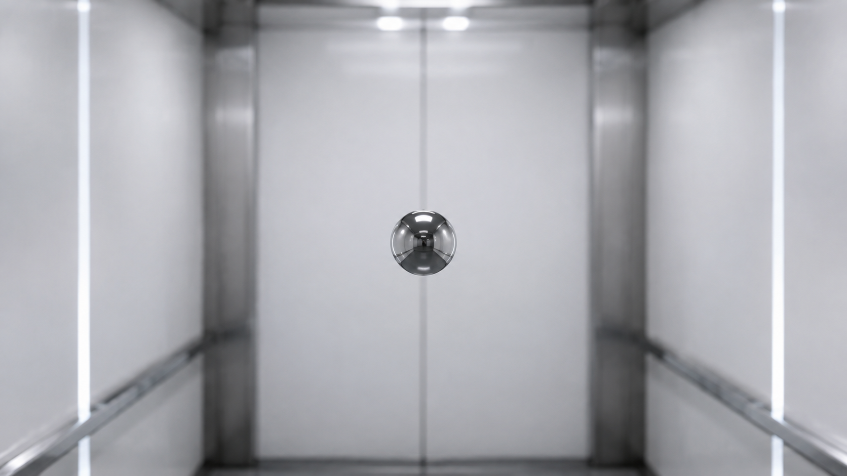Bille métallique en suspension au milieu d'une cabine d'ascenseur blanche et vide, sans personne autour.