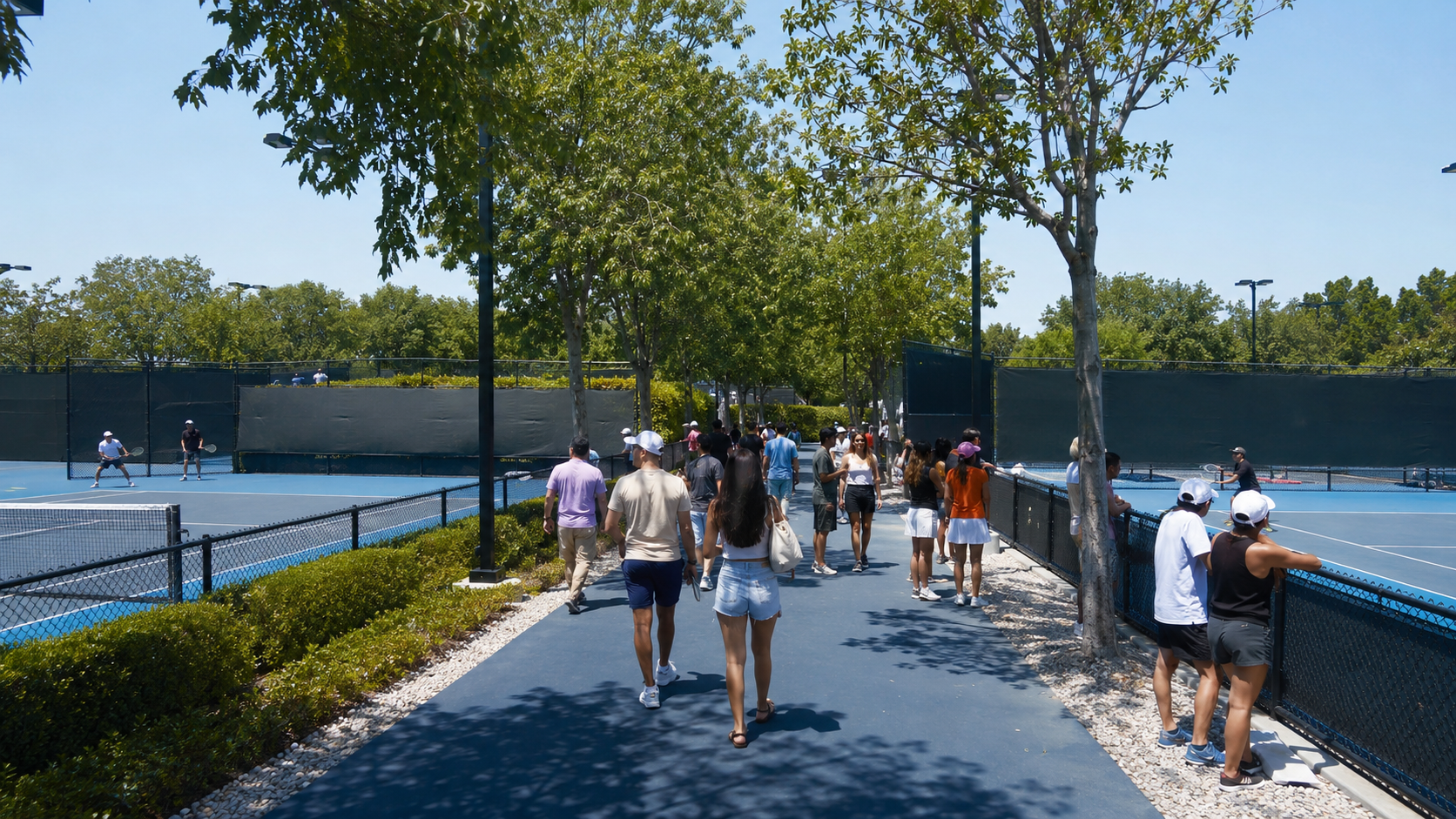 Des spectateurs circulent librement entre les courts annexes d’un grand tournoi de tennis