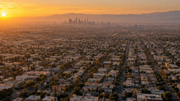 Vue aérienne du bassin de Los Angeles au couchant : un quadrillage sans fin de maisons basses à toit plat jusqu’aux montagnes.