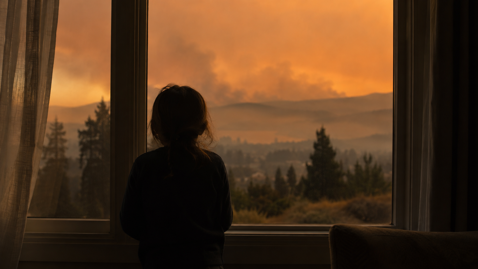 Un enfant de dos devant une fenêtre, face à un horizon voilé de brume orangée.