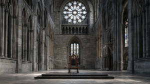 Nef déserte d’une grande cathédrale gothique nordique en pierre grise, un fauteuil de bois sculpté seul sur une estrade sous la lumière froide d’une rosace.