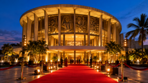L'ancien Théâtre national de Lagos illuminé au crépuscule, tapis rouge déroulé à l'entrée